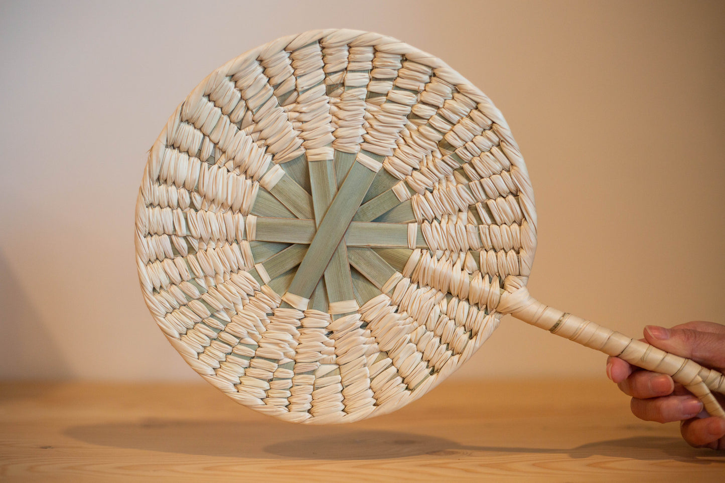Éventail rond artisanal en feuille de palmier